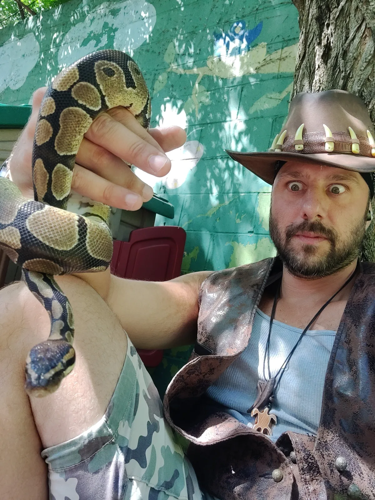 A handler holding a coiled patterned snake